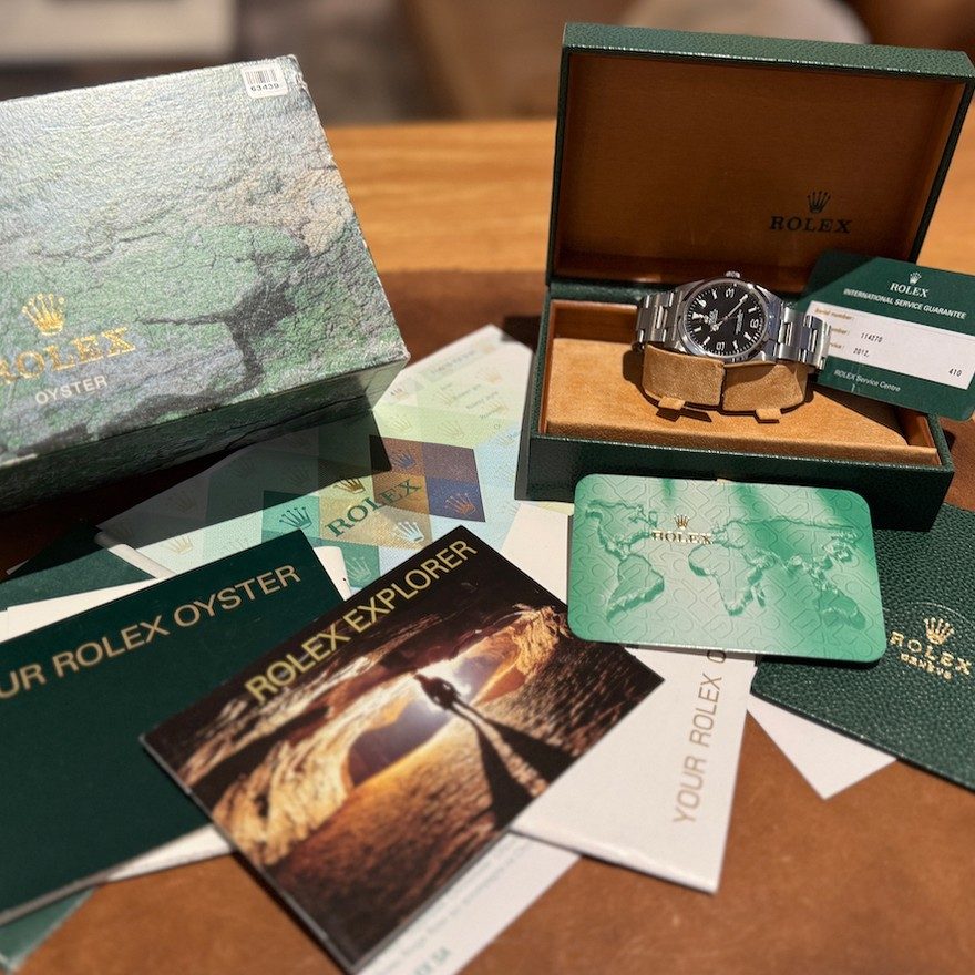 A Rolex Explorer with its box, papers and booklets laid out