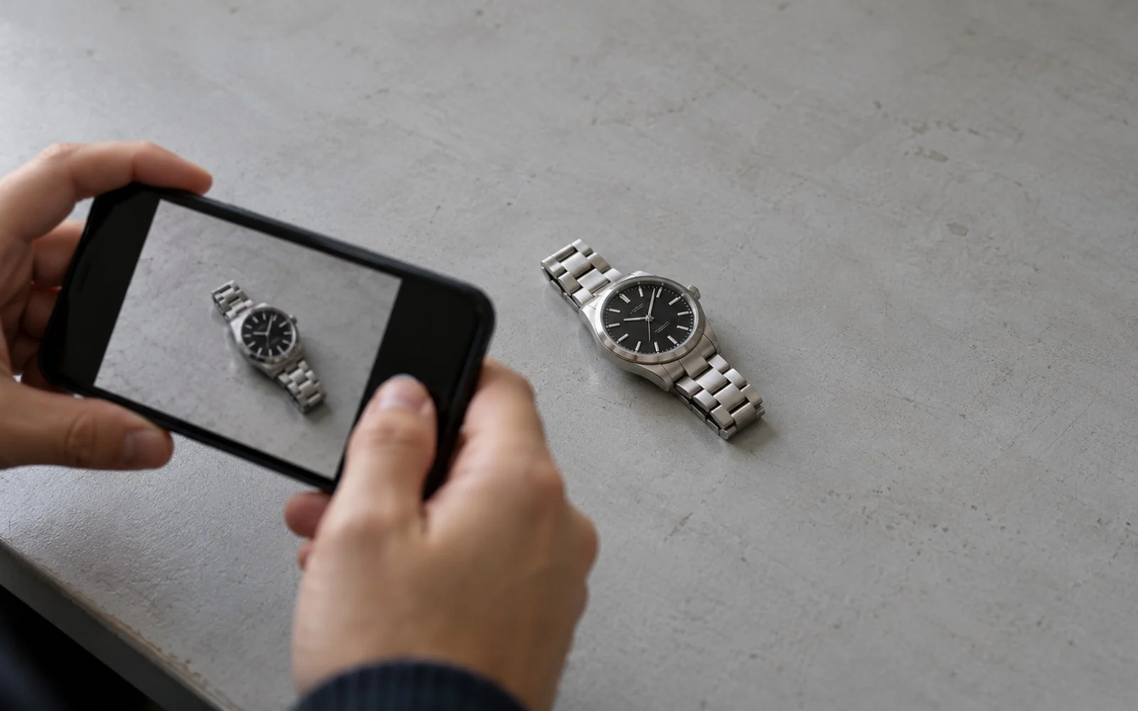 Generated illustration of someone using a phone to photograph a watch on a plain desk.